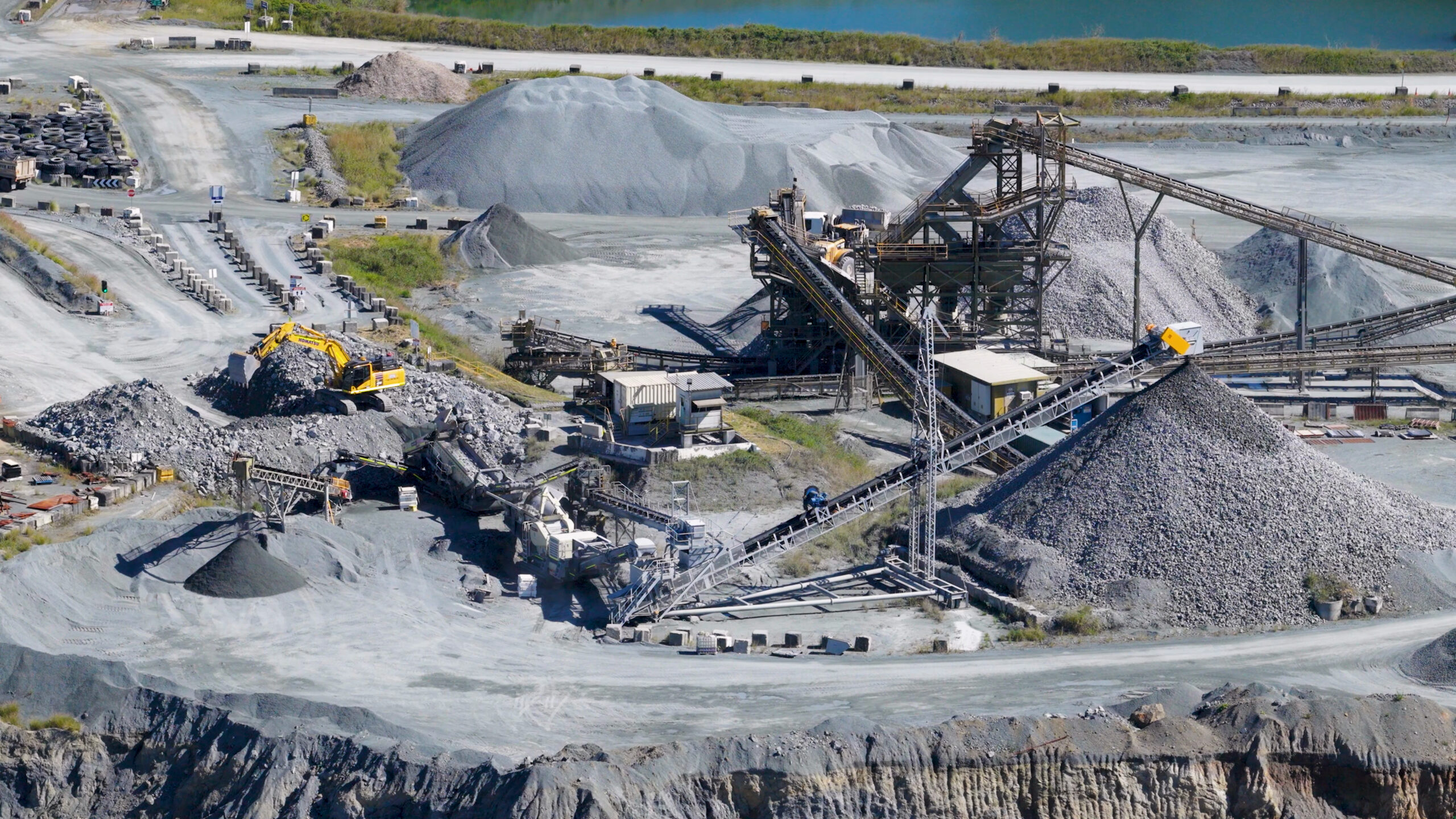 Aerial view of industrial quarry operations with excavator and conveyor belts